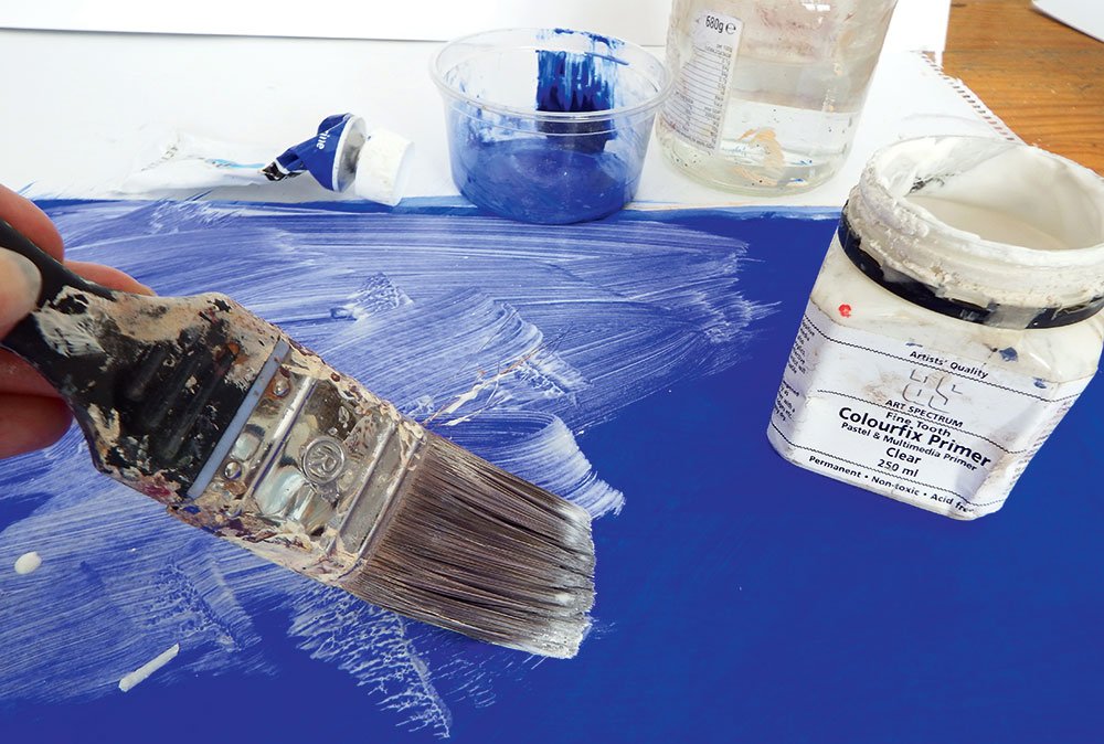 Applying a clear coat of primer to a bright blue surface with a brush