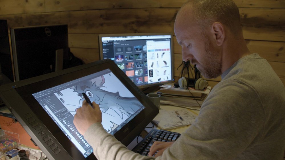 An art director sketches on a large drawing tablet