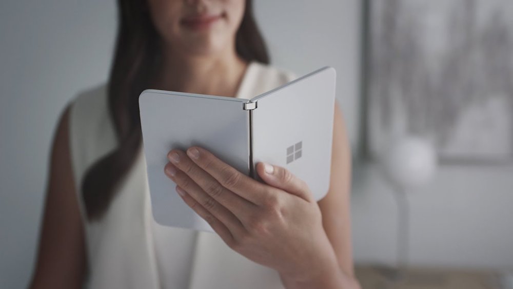 Smiling woman holding foldable device