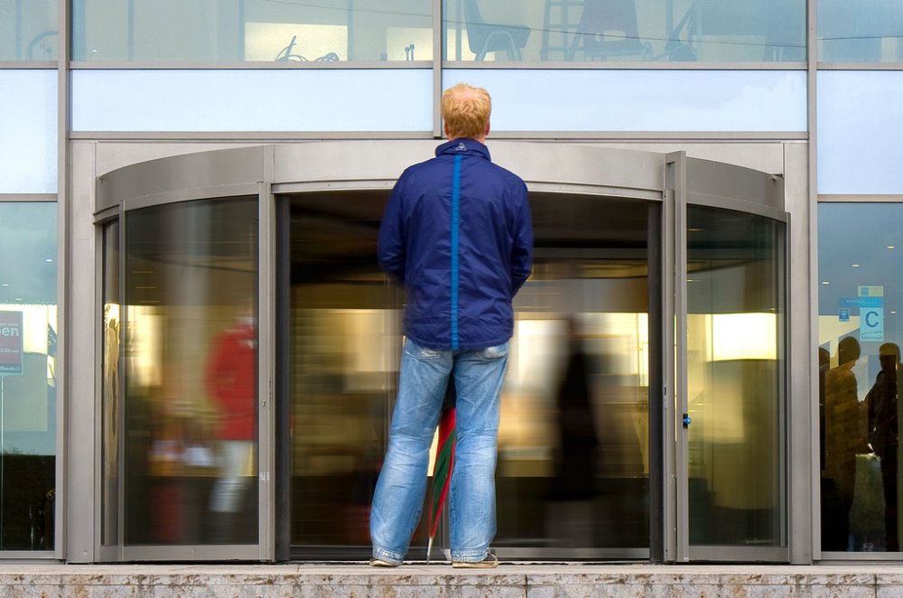Man standing in front of revolving door