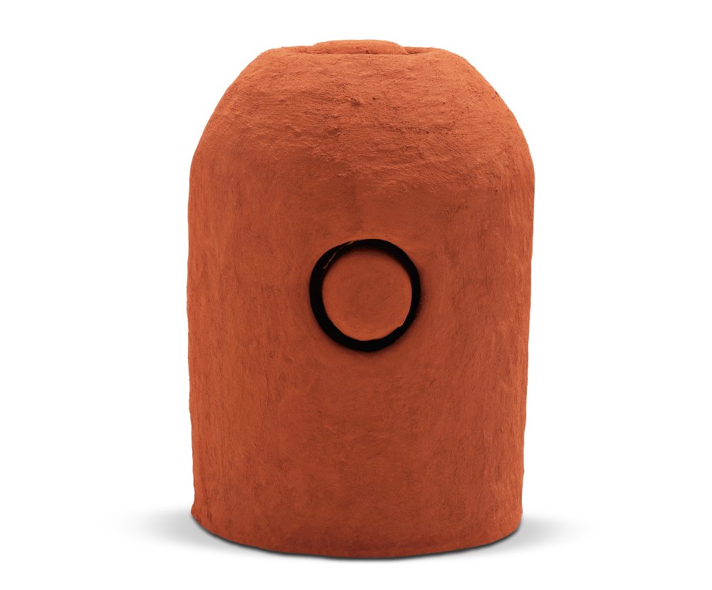 Orange/brown sculpture with rounded top and a circular shape cut into the middle