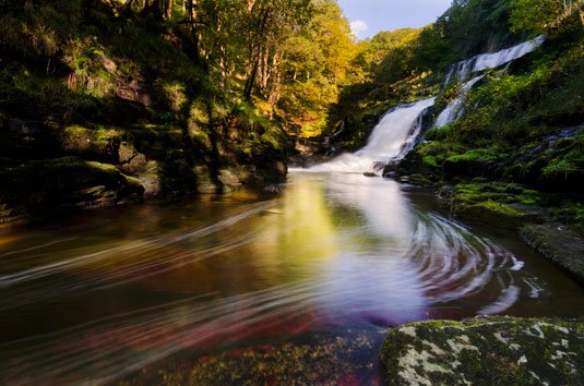 Waterfall and lake in shadow and sun