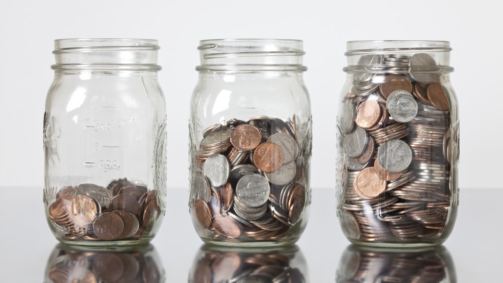 three jars of coins filled to different levels