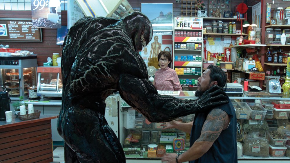 Venom grabbing a character by the neck in a convenience store