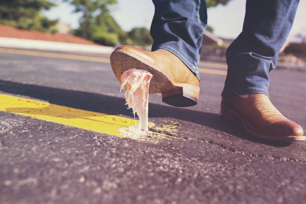 Feet of person who has stepped in chewing gum