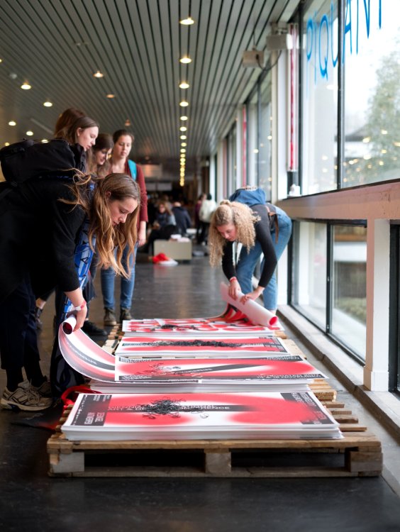 people rolling up posters