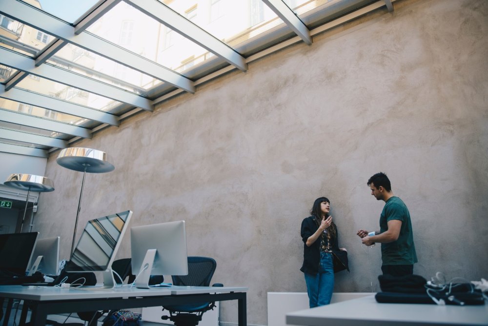 Man and woman having a discussion in the corner of an office