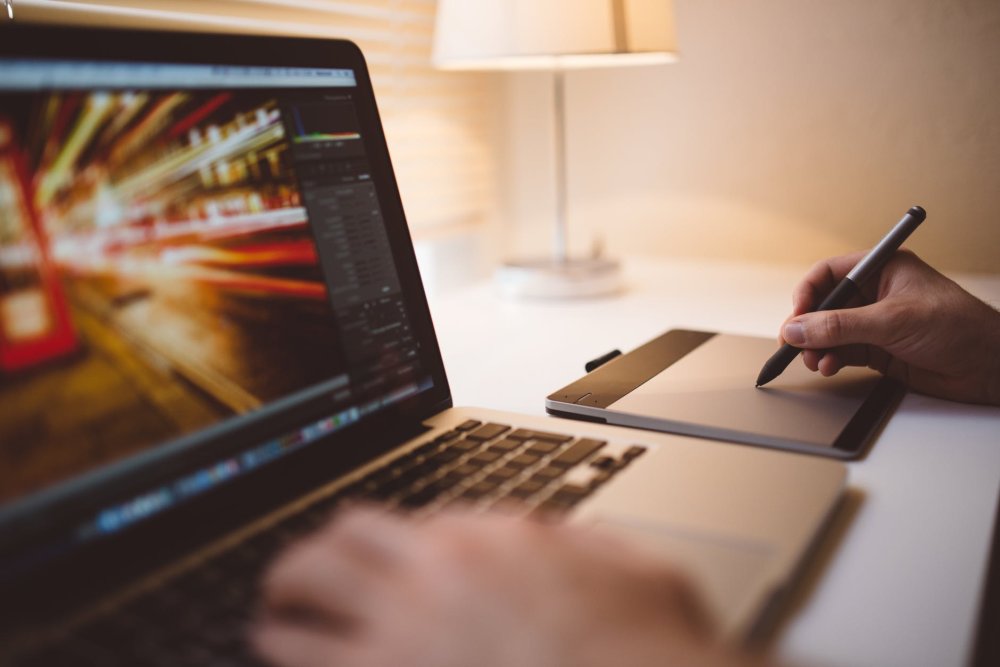 Person using laptop keyboard and drawing tablet