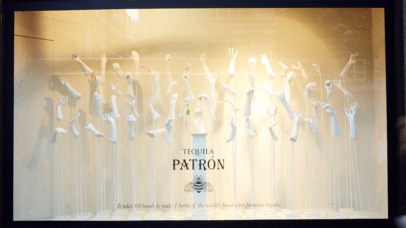 Window display shows hand scultpures and a bottle of Tequila Patron