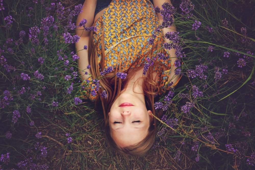 Woman lying in a field with her eyes closed