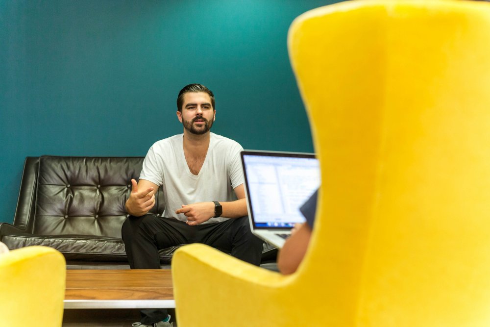 Man facing an interviewer in a yellow chair