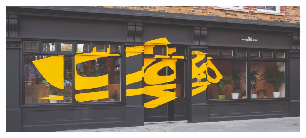 Black building frontage with stylish yellow lettering