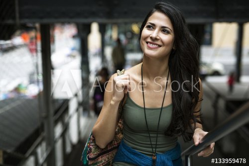 Happy woman looking away while moving up steps